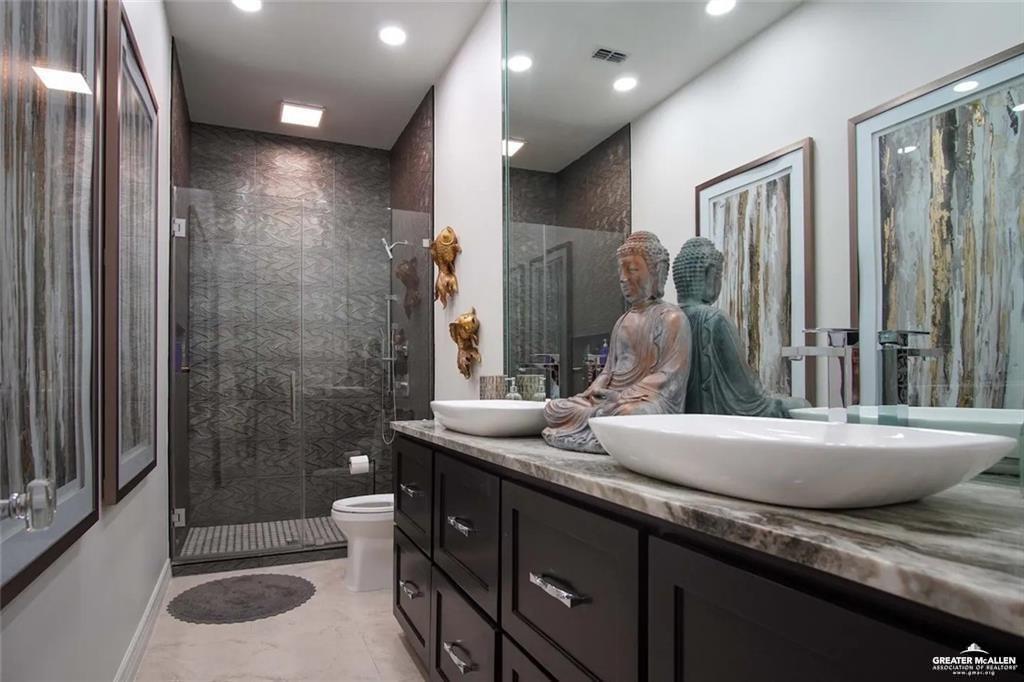 1413 Encantado Circle Palmview, TX 78572 - Photo 19 of 25 a bathroom with a granite countertop sink a toilet and shower