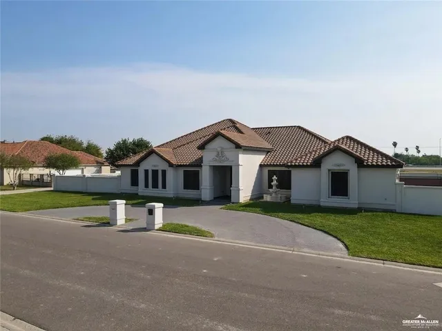 a view of a house with a yard and large trees