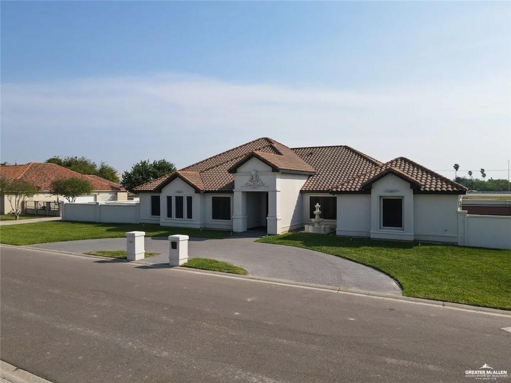 1413 Encantado Circle Palmview, TX 78572 - Photo 2 of 25 a view of a house with a yard and large trees