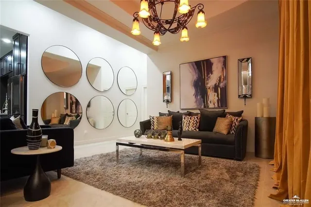 a living room with furniture a chandelier and a mirror
