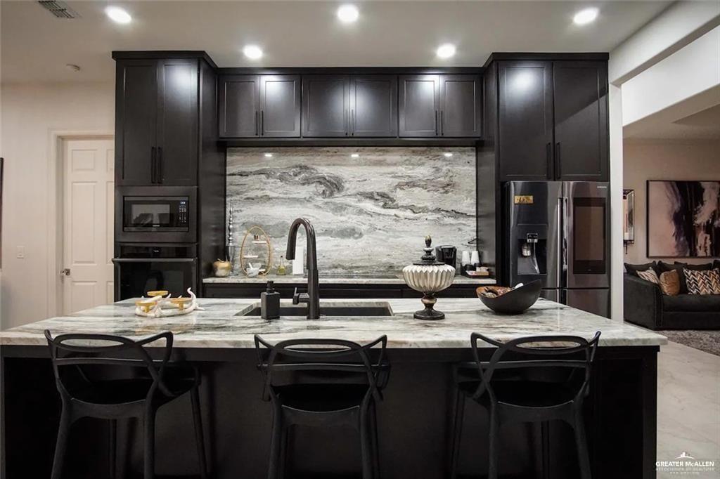 1413 Encantado Circle Palmview, TX 78572 - Photo 9 of 25 a kitchen with stainless steel appliances a sink stove and cabinets