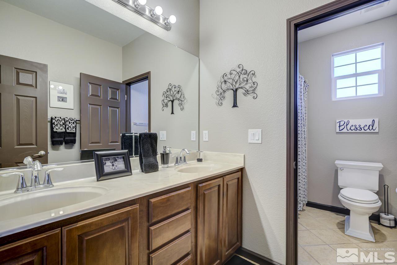 460 Ruffian Court Reno, NV 89521 - Photo 17 of 25 a bathroom with a toilet a sink and mirror