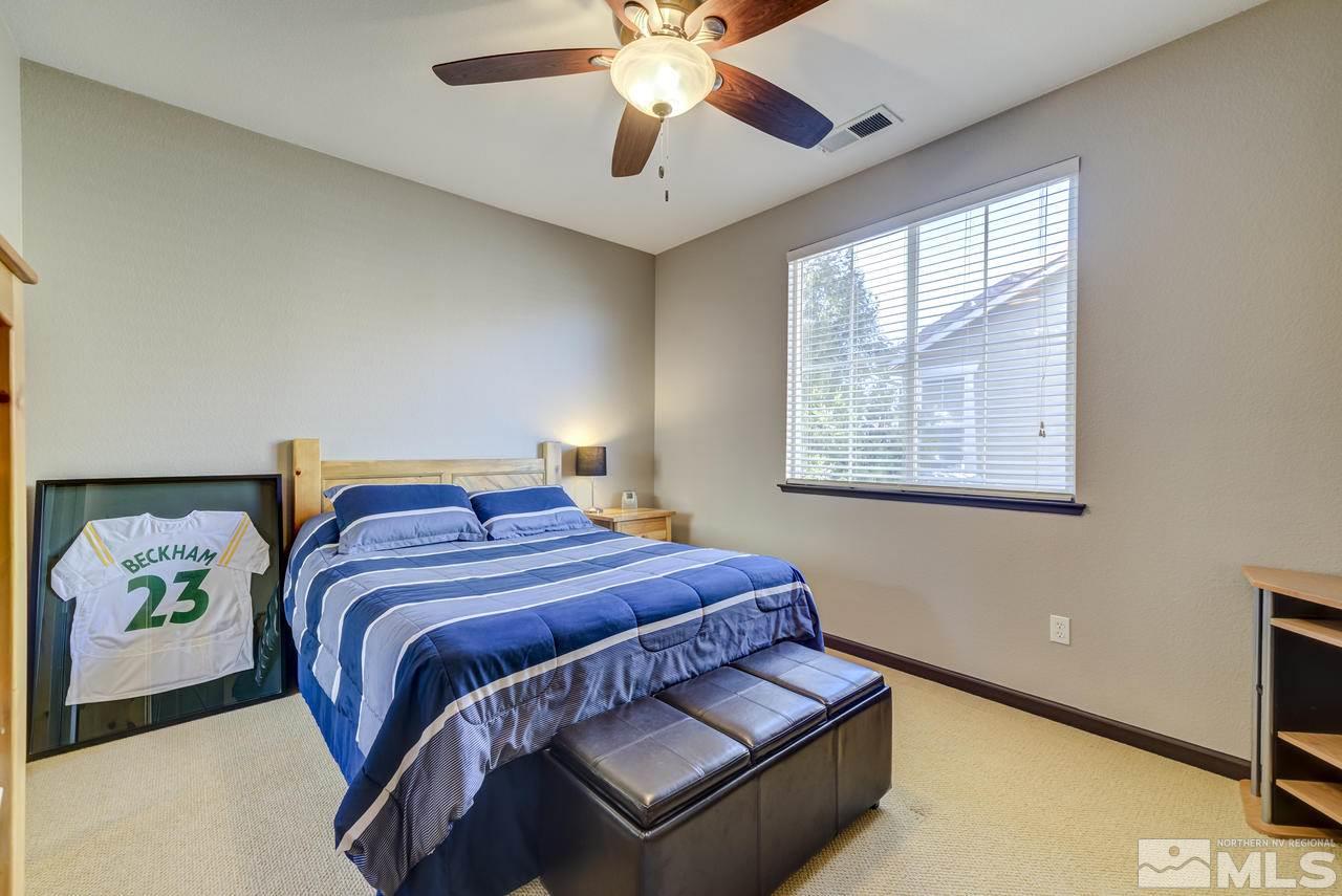 460 Ruffian Court Reno, NV 89521 - Photo 18 of 25 a bedroom with a bed and a chandelier