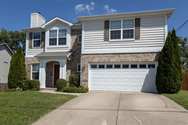 a front view of a house with a yard and garage