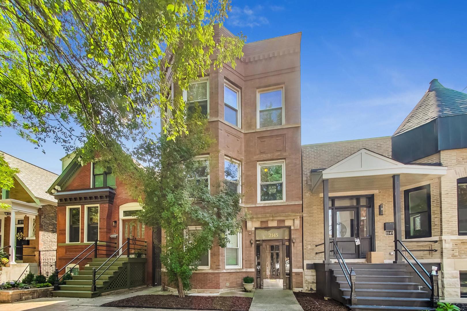 2145 West Thomas Street, Unit 3 Chicago, IL 60622 - Photo 1 of 17 front view of a brick house with a large tree