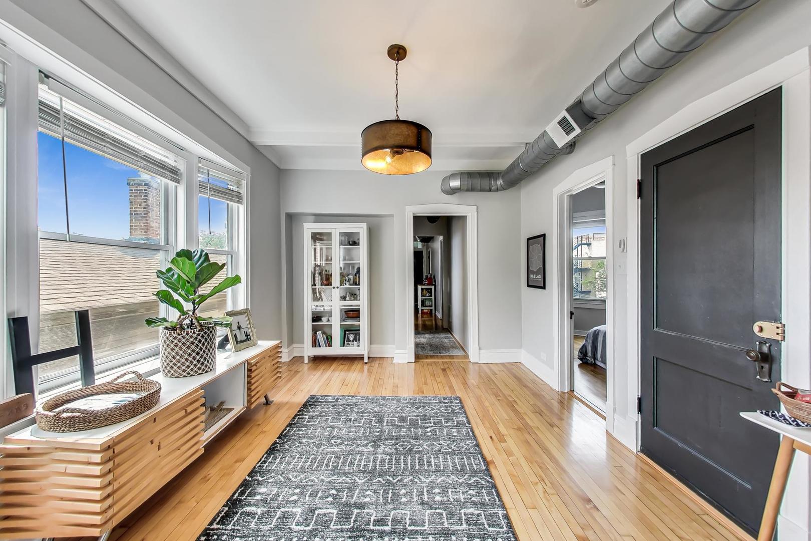 2145 West Thomas Street, Unit 3 Chicago, IL 60622 - Photo 3 of 17 a hallway with wooden floor and a rug