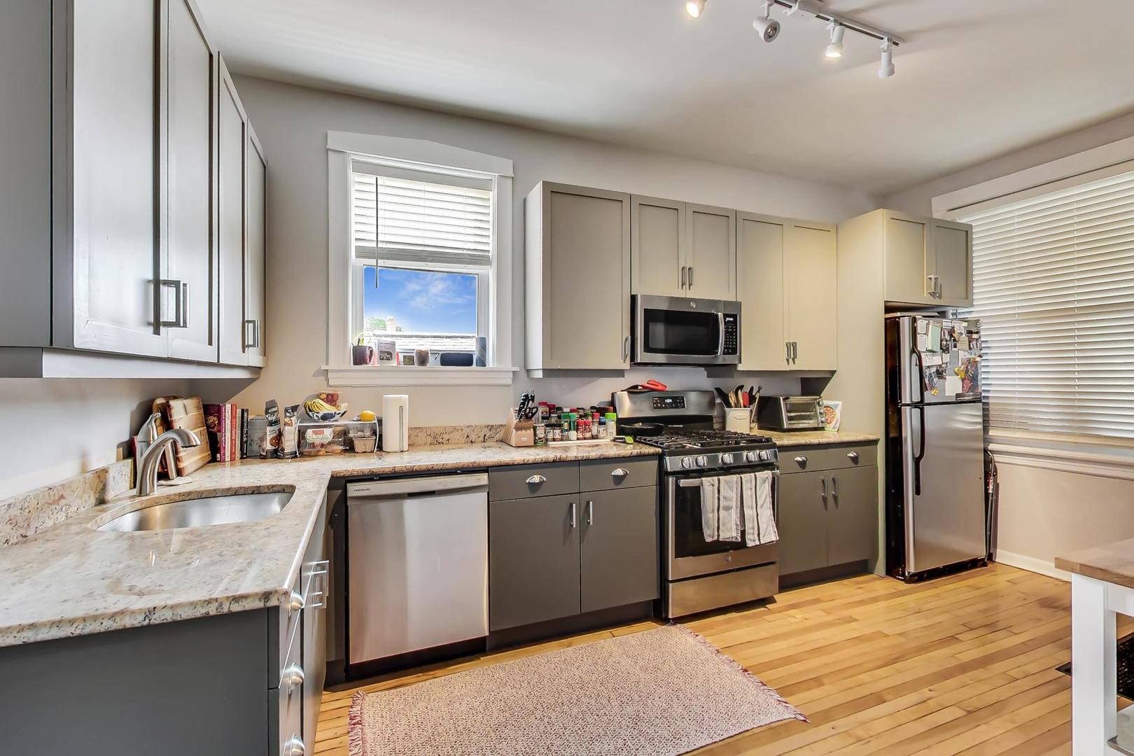 2145 West Thomas Street, Unit 3 Chicago, IL 60622 - Photo 6 of 17 a kitchen with stainless steel appliances granite countertop a sink stove microwave and refrigerator