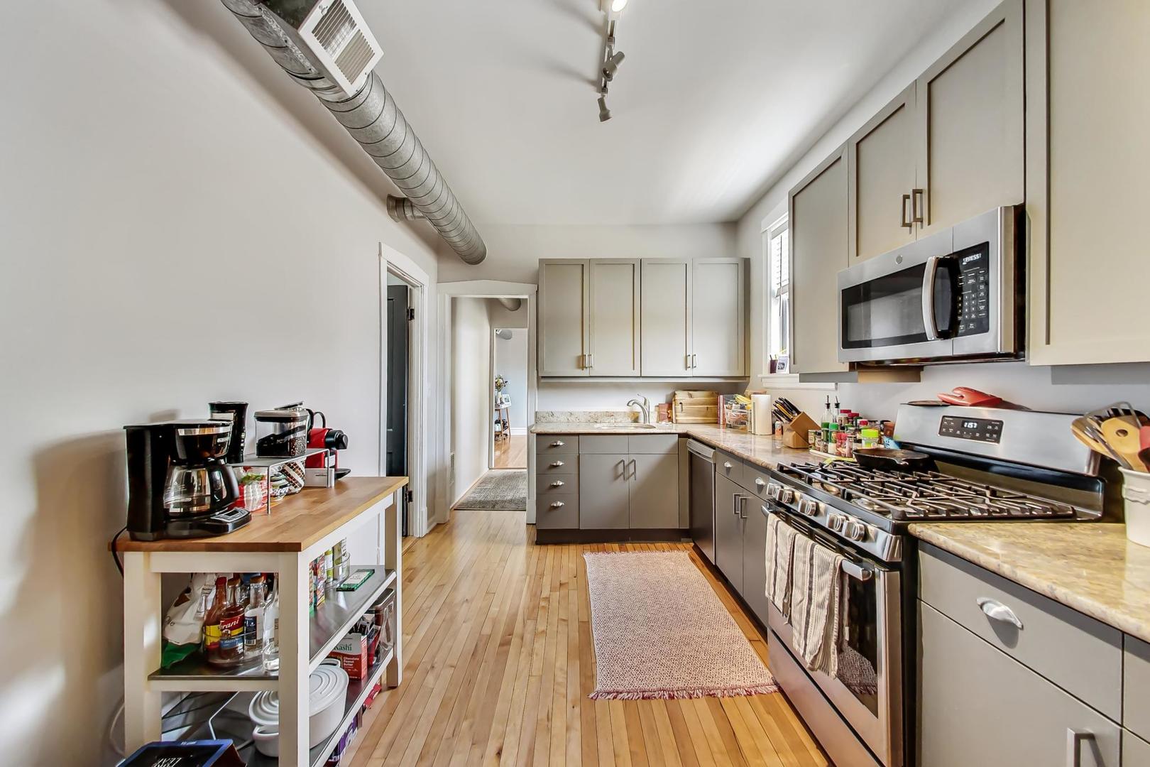 2145 West Thomas Street, Unit 3 Chicago, IL 60622 - Photo 7 of 17 a kitchen that has a lot of cabinets and wooden floor