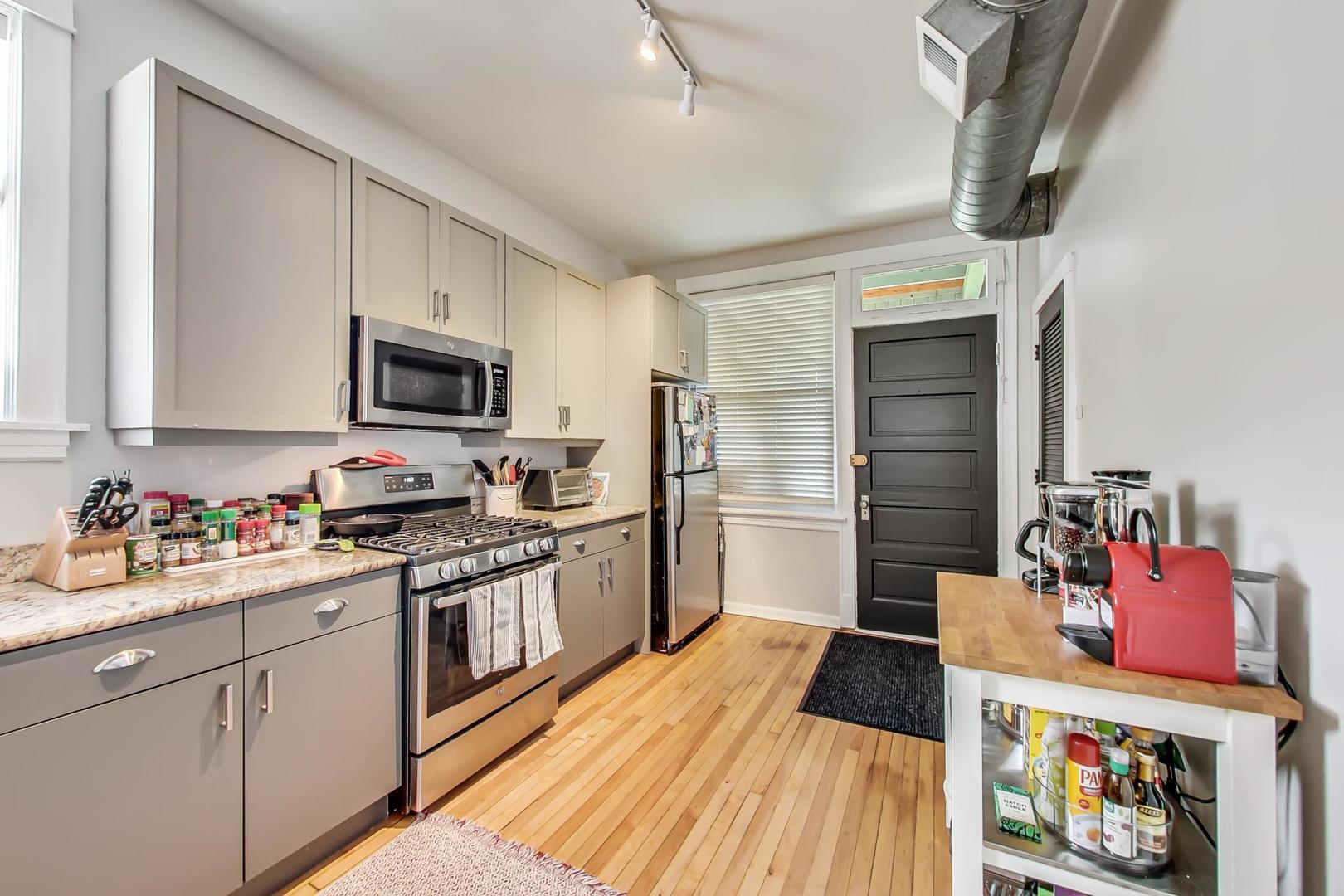 2145 West Thomas Street, Unit 3 Chicago, IL 60622 - Photo 8 of 17 a kitchen with stainless steel appliances a stove refrigerator sink and cabinets