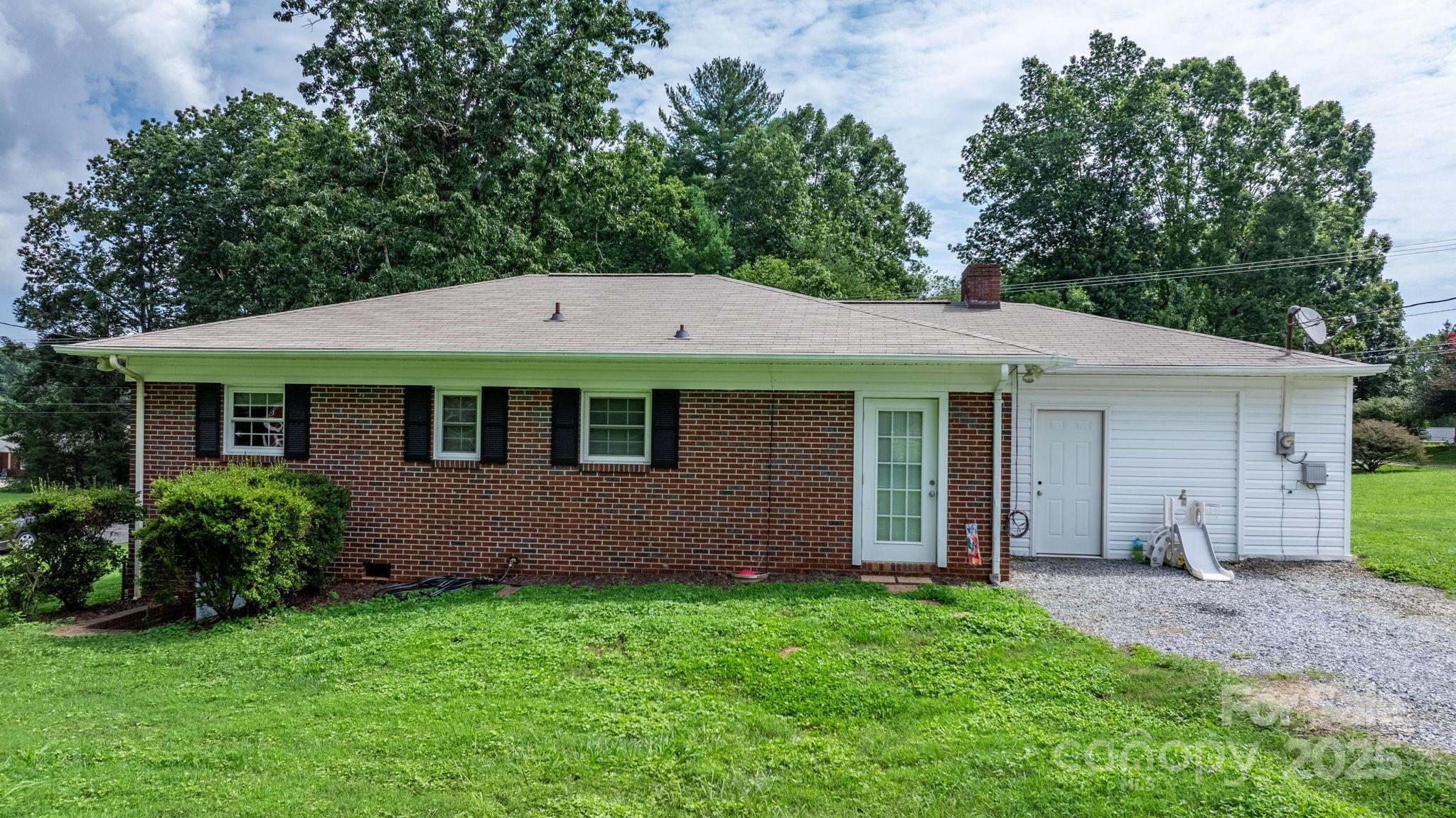 1838 Connelly Springs Road Lenoir, NC 28645 - Photo 24 of 24 a view of a house with a yard plants and large tree