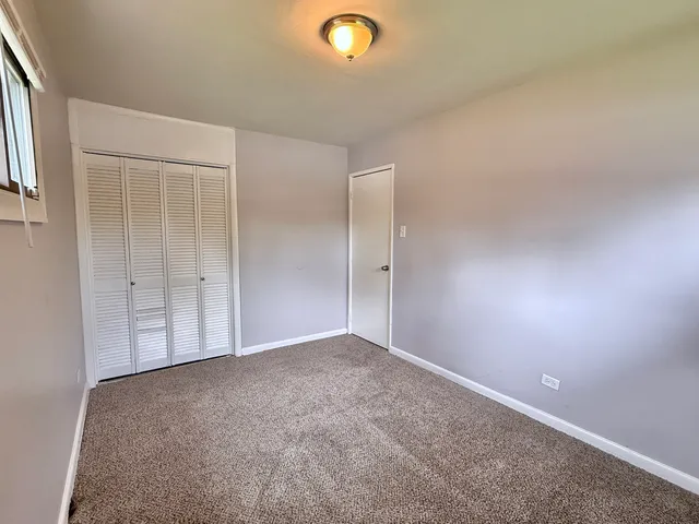 an empty room with closet area and natural light