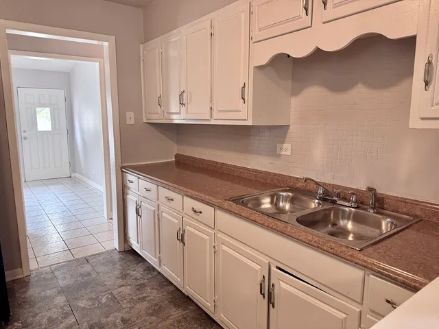 a kitchen with white cabinets and a sink