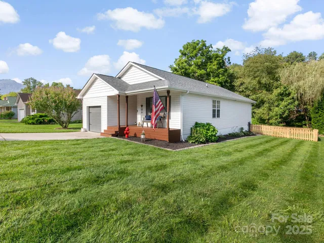 a view of a house with backyard and a tree