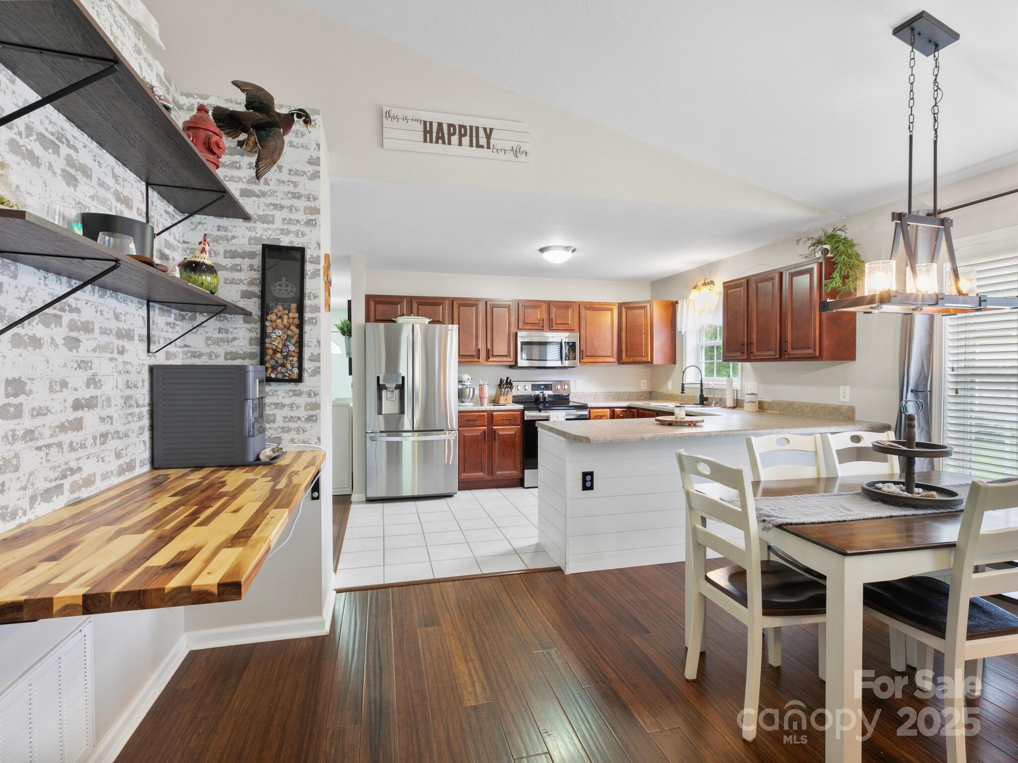 61 Village Street Clyde, NC 28721 - Photo 13 of 30 a kitchen with stainless steel appliances kitchen island granite countertop a table chairs and a refrigerator