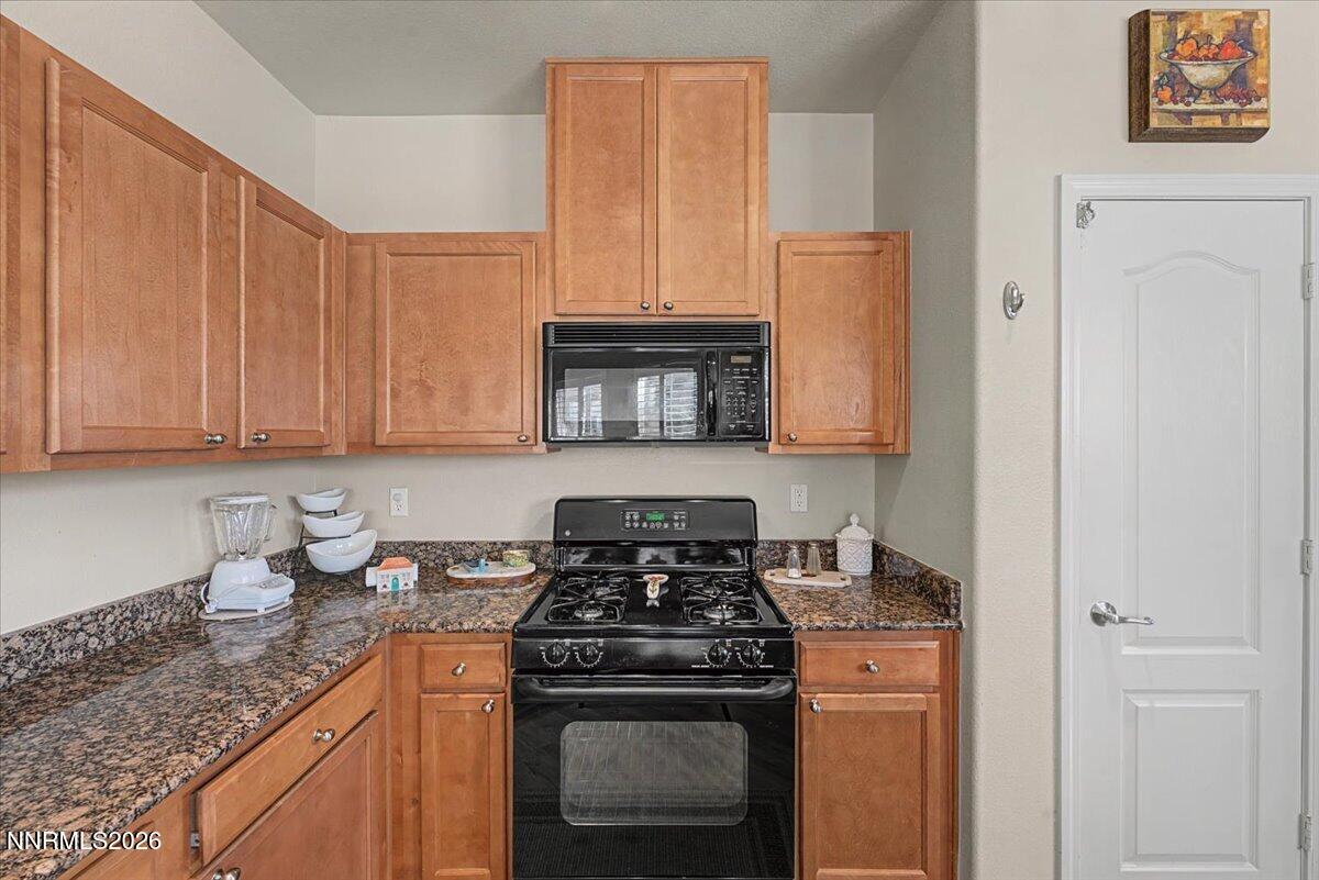 17000 Wedge Parkway, Unit 2625 Reno, NV 89511 - Photo 11 of 42 a kitchen with granite countertop stainless steel appliances a stove a refrigerator and cabinets