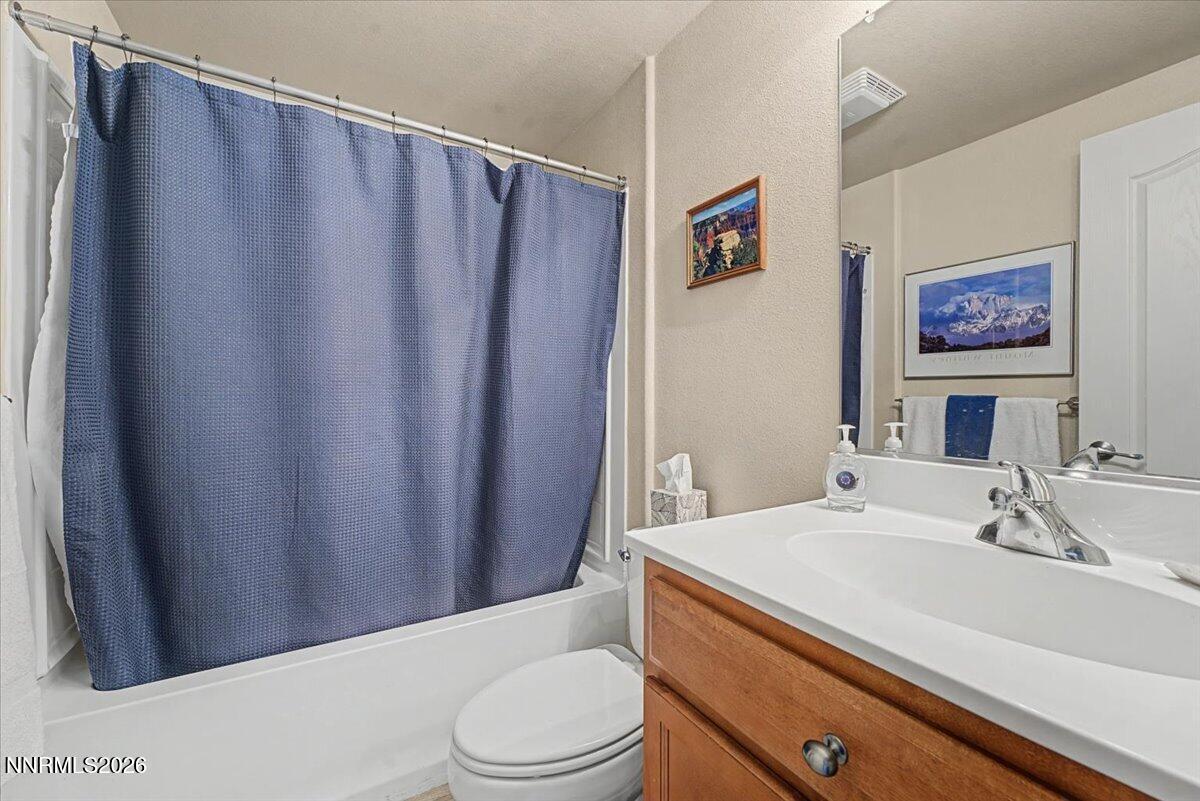 17000 Wedge Parkway, Unit 2625 Reno, NV 89511 - Photo 18 of 42 a bathroom with a sink a toilet a shower curtain and a mirror