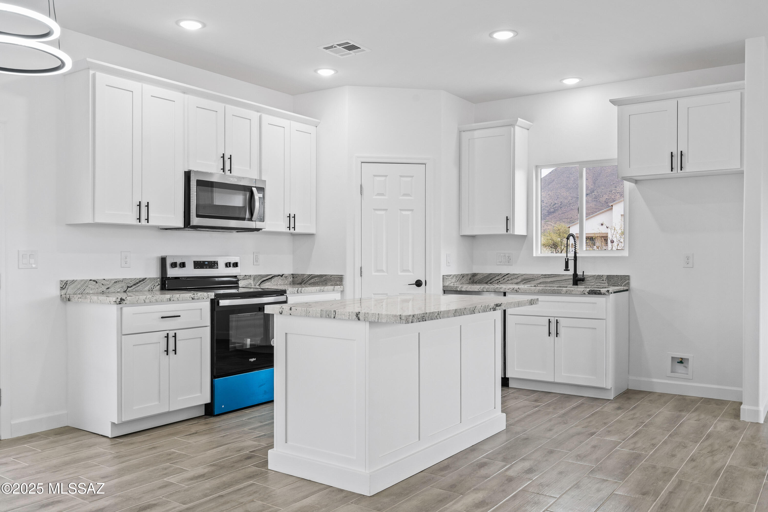 1851 Calle Salmon Rio Rico, AZ 85648 - Photo 12 of 29 a kitchen with white cabinets sink and stainless steel appliances
