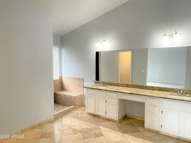 a spacious bathroom with a granite countertop sink and a mirror