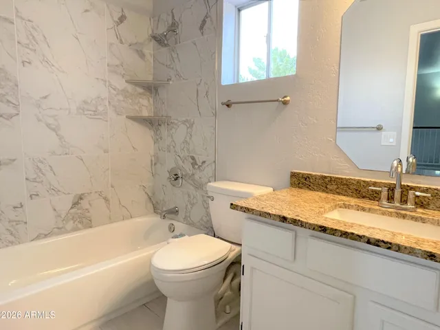 a bathroom with a granite countertop toilet sink and bathtub