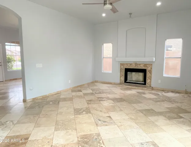 an empty room with fireplace and windows
