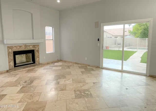 a view of an empty room with a fireplace and a window