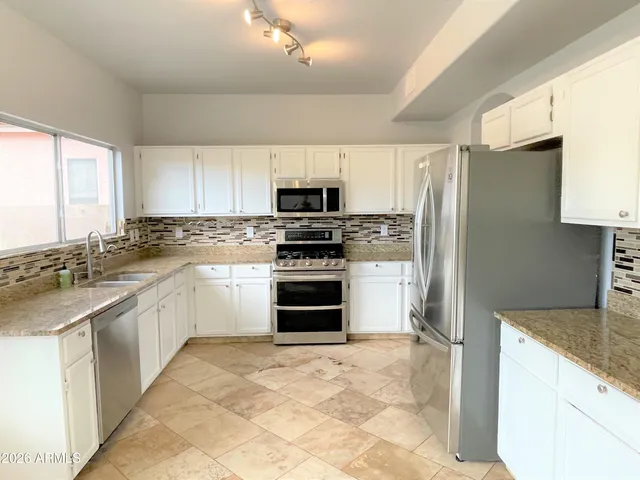 a kitchen with granite countertop a refrigerator and a sink