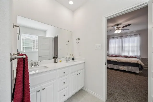 a en suite bathroom with a double vanity sink a large mirror and a bathtub