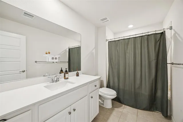 a bathroom with a double vanity sink toilet and shower