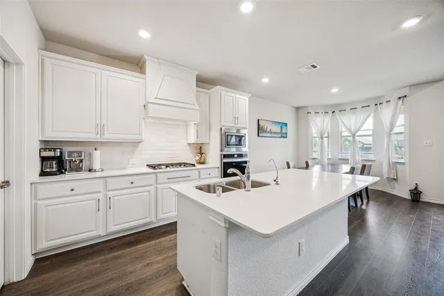 a kitchen with a sink stove and cabinets