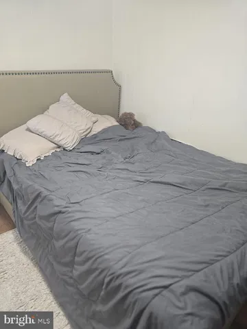 a bed with a white comforter and pillows