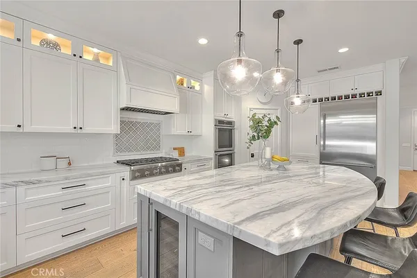 a kitchen with kitchen island a counter space a sink stainless steel appliances and cabinets