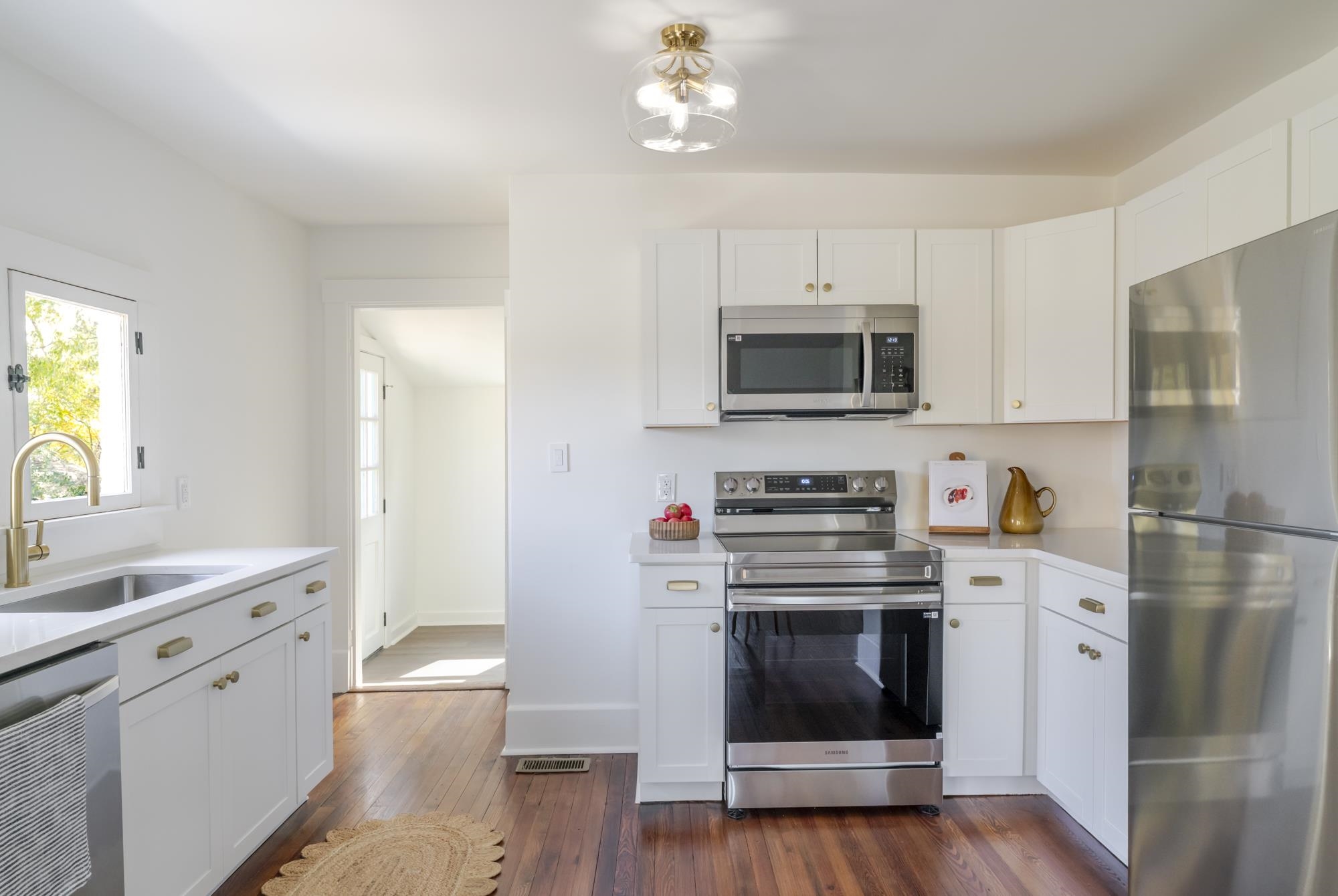 2216 Noon Street Staunton, VA 24401 - Photo 13 of 26 a kitchen with stainless steel appliances a stove a microwave and white cabinets