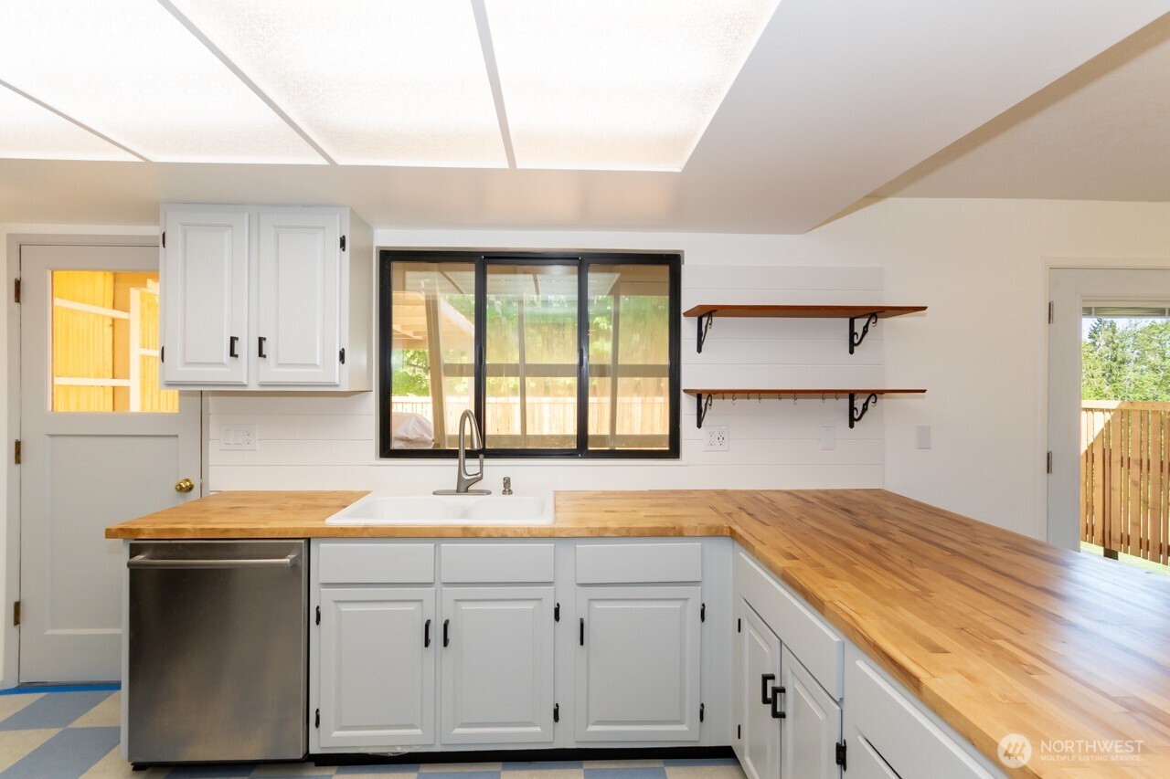 63 East Arnette Road Port Angeles, WA 98362 - Photo 15 of 40 a kitchen with granite countertop a sink white cabinets and a large window