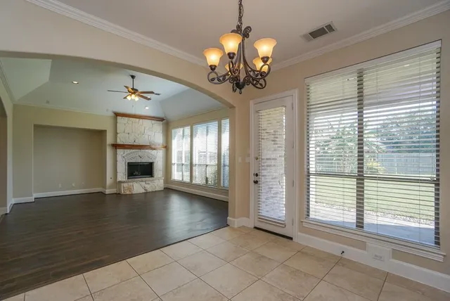 a view of a livingroom with a chandelier curtains and large windows