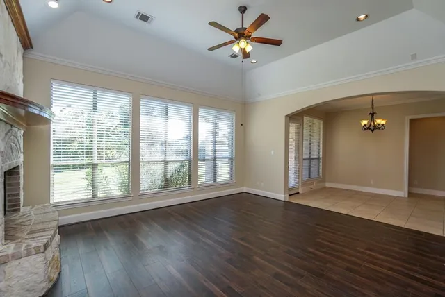 a view of an empty room with a window and wooden floor