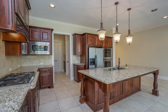 a kitchen with stainless steel appliances granite countertop a stove a sink and a refrigerator