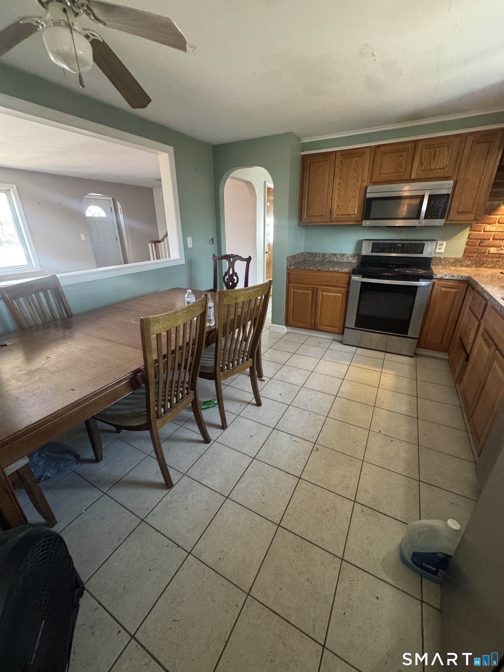 105 Crown Street Bristol, CT 06010 - Photo 9 of 20 a kitchen with granite countertop a stove a sink and a microwave