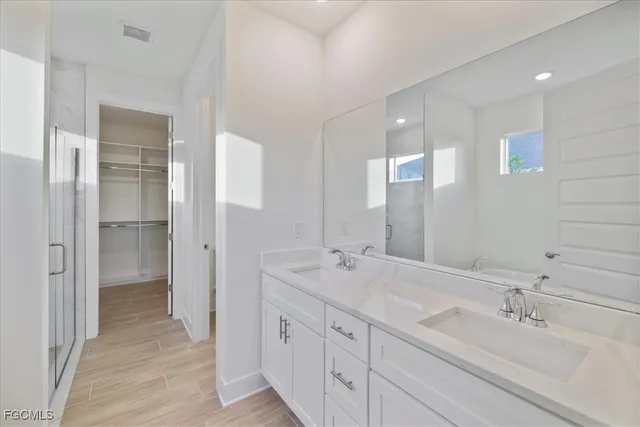 a spacious bathroom with a double vanity sink mirror and shower