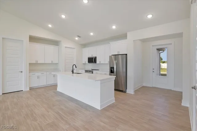 a view of kitchen with sink and refrigerator
