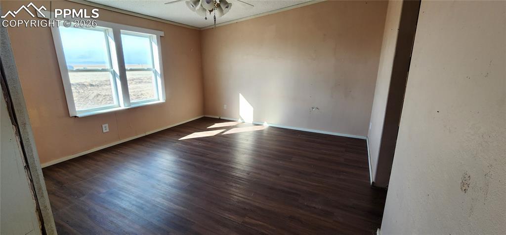 31995 North Neely Road Yoder, CO 80864 - Photo 5 of 21 an empty room with wooden floor and windows