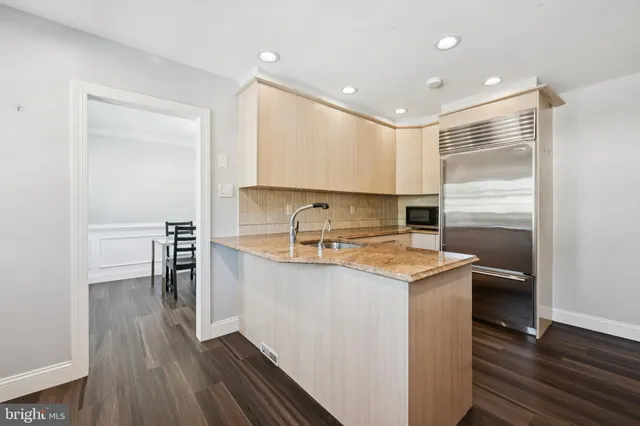 a kitchen with a sink refrigerator and cabinets
