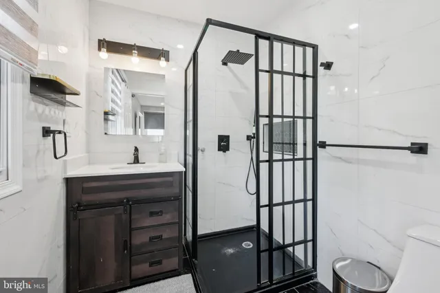 a bathroom with a sink a toilet and shower