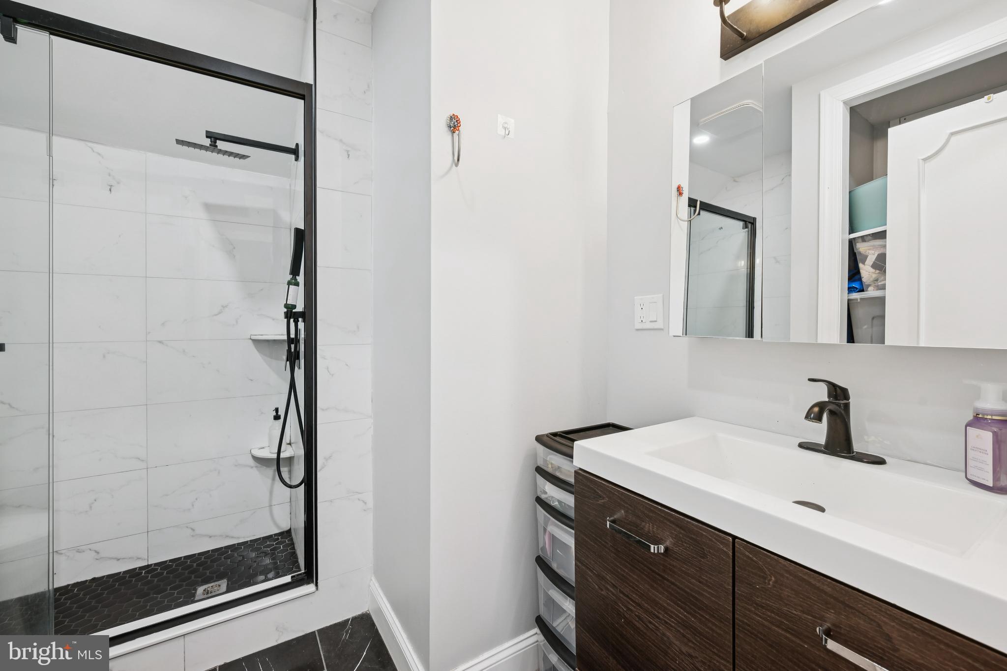 9810 Bridle Road Philadelphia, PA 19115 - Photo 24 of 25 a bathroom with a shower sink and mirror