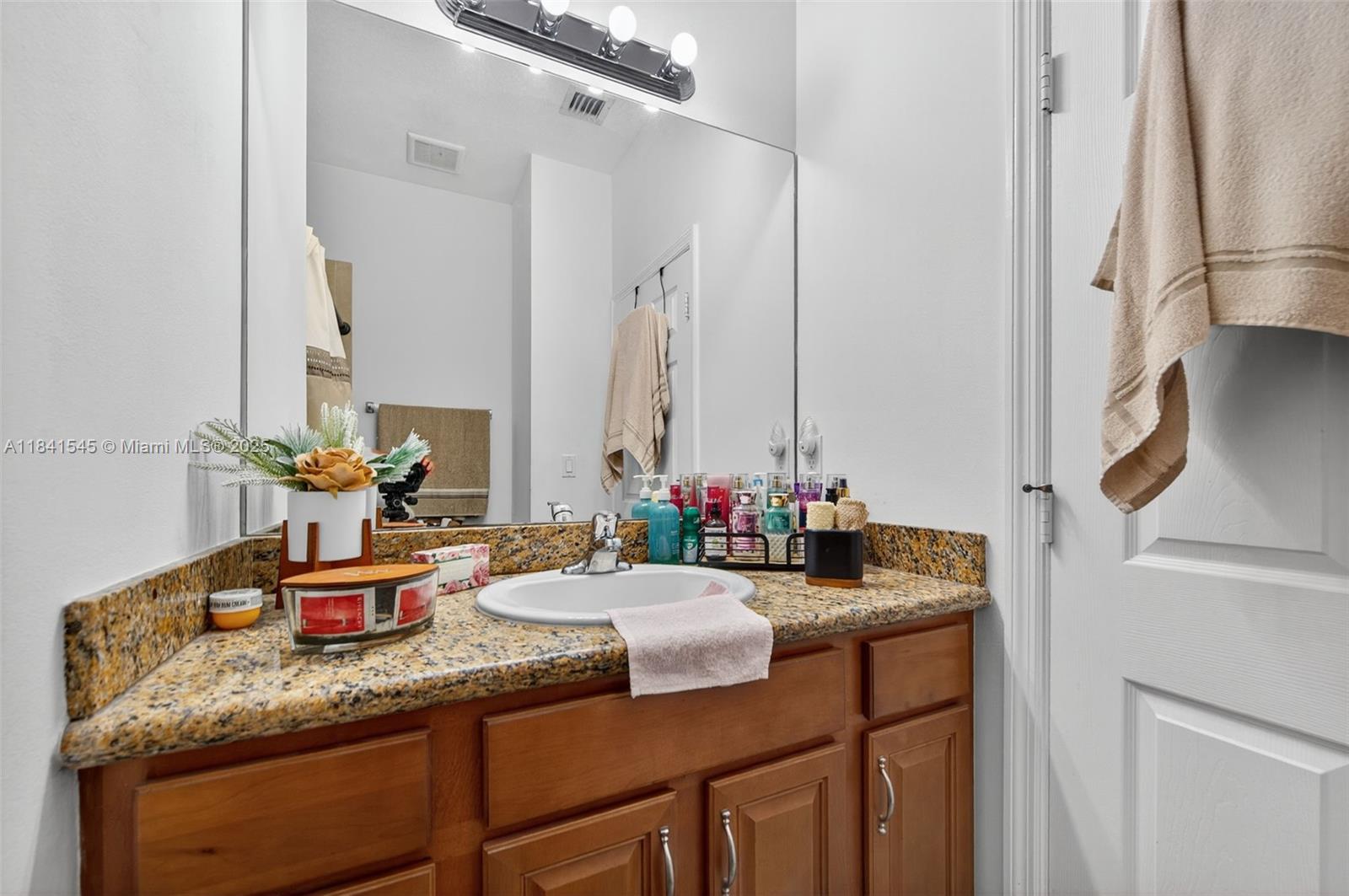 14615 Southwest 14 Street, Unit 14615 Pembroke Pines, FL 33027 - Photo 26 of 49 a bathroom with a granite countertop sink and a mirror