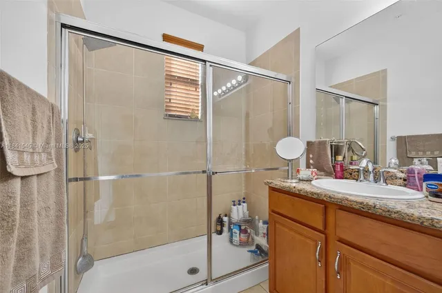 a bathroom with a granite countertop sink a mirror a shower and a bathtub