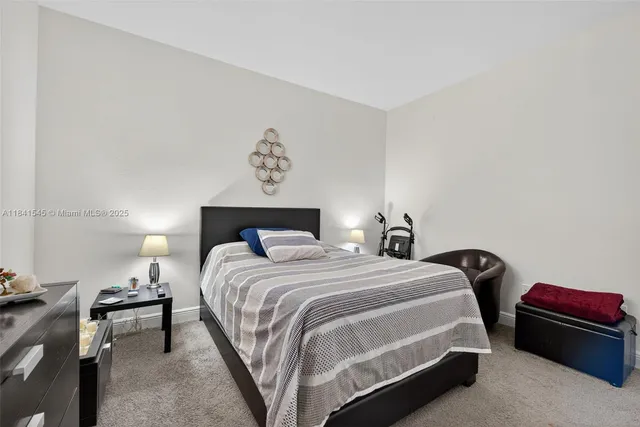 a bedroom with a bed and a lamp on dresser