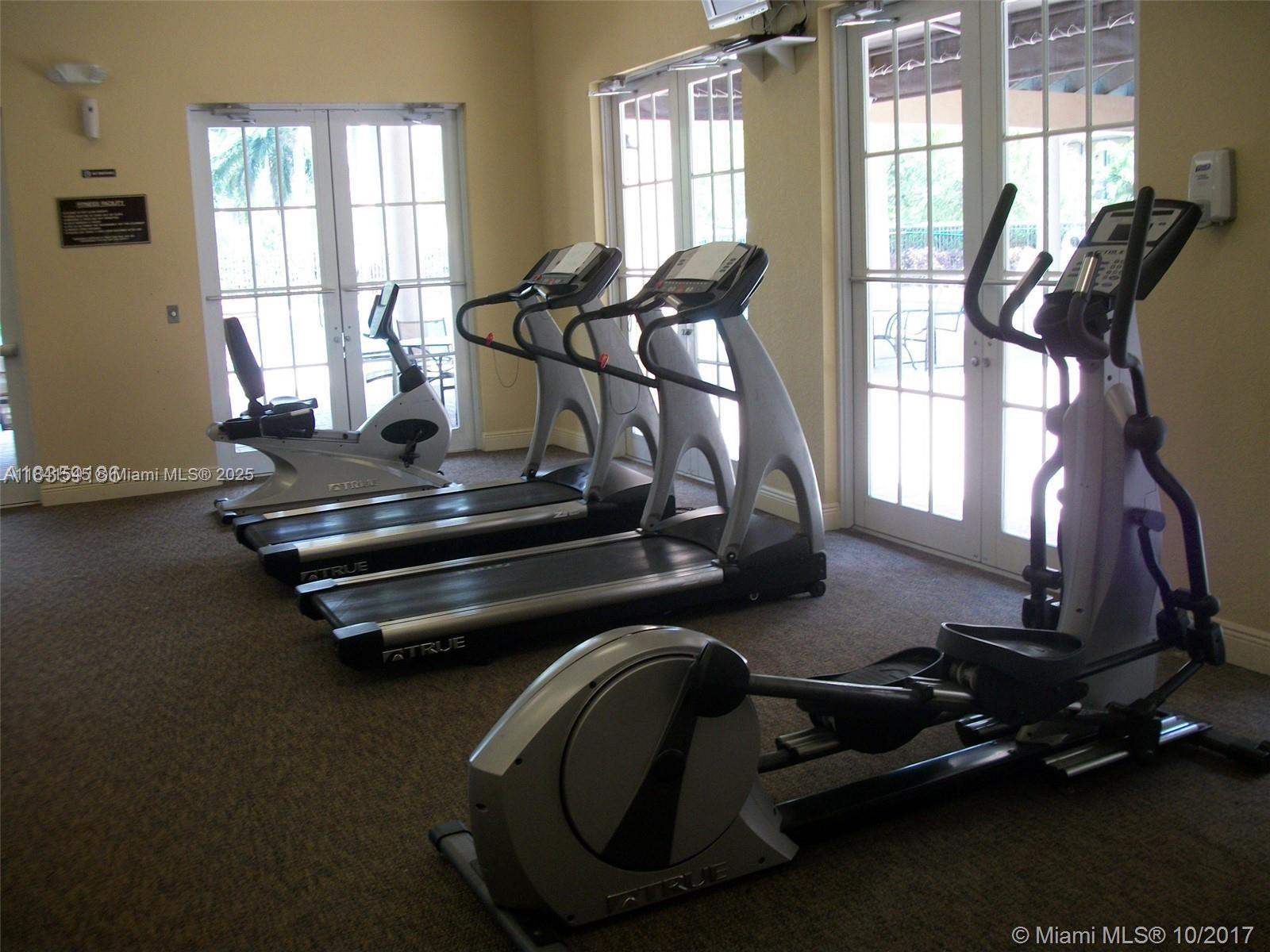 14615 Southwest 14 Street, Unit 14615 Pembroke Pines, FL 33027 - Photo 6 of 49 a room with gym equipment and windows