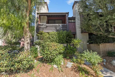 a backyard of a house with outdoor seating and plants