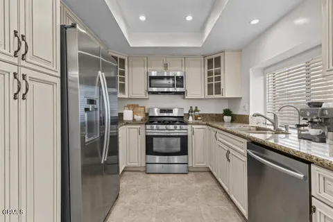 a kitchen with stainless steel appliances granite countertop a refrigerator and a stove top oven