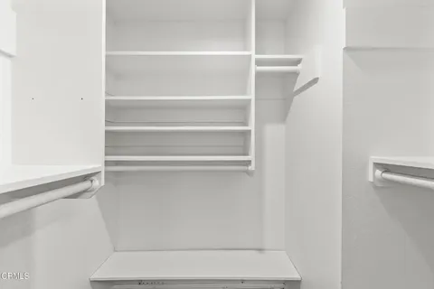 a view of walk in closet with empty racks
